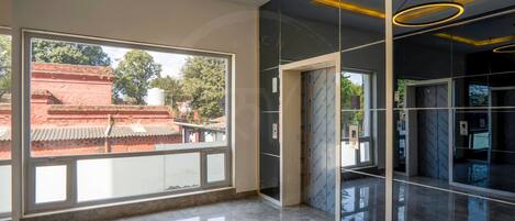 A modern interior with large windows, reflective flooring, and contemporary lighting fixtures.