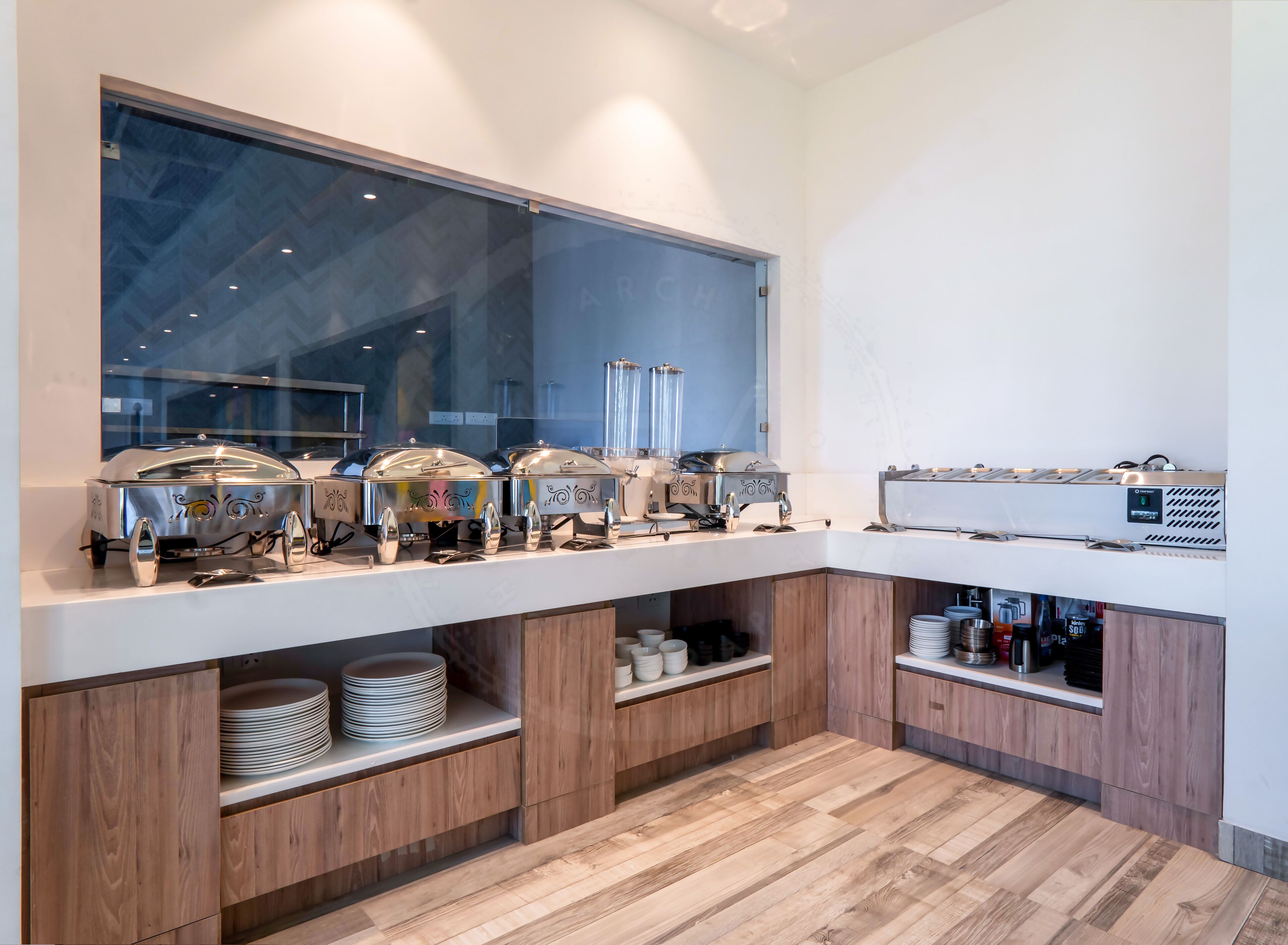 A modern kitchen with a large window, stainless steel appliances, and wooden cabinetry.