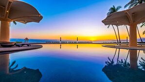 A pool with a sunset view, palm trees, and lounge chairs. - Ocean Front Penthouse, Pool, Sleeps 6 people (Bucerías)