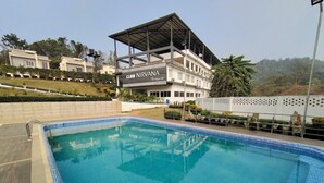 A swimming pool with a covered area labeled 'Club Nirvana'. - Club Nirvana Boutique Resort Pure-Veg (Sonapur)