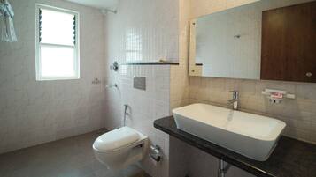 A bathroom with a toilet, sink, and shower.