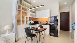 Una cocina moderna con gabinetes blancos, encimera negra y microondas integrado.