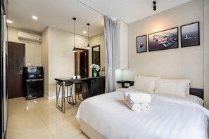 A hotel room with a bed, a desk, a chair, a TV, and a bathroom. - WE HOME Ton That Tung (Ho Chi Minh City)