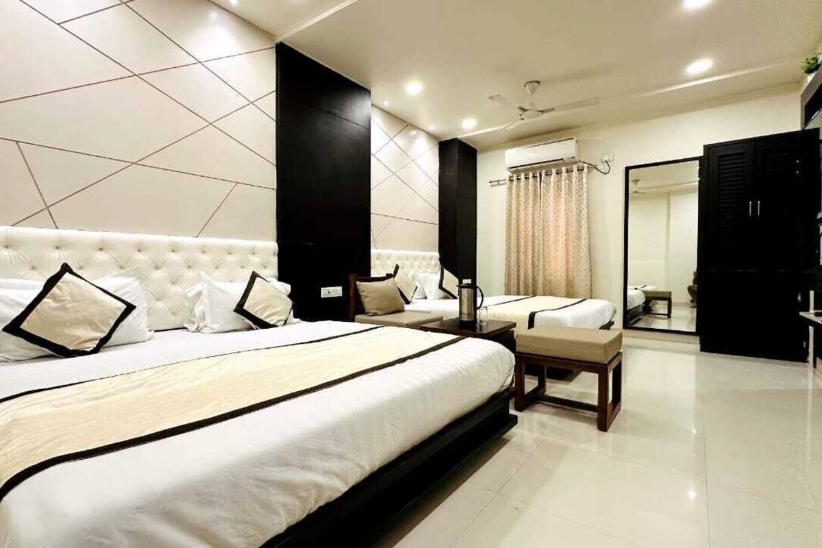 Une chambre moderne avec un grand lit, une table de chevet, un miroir et un téléviseur.