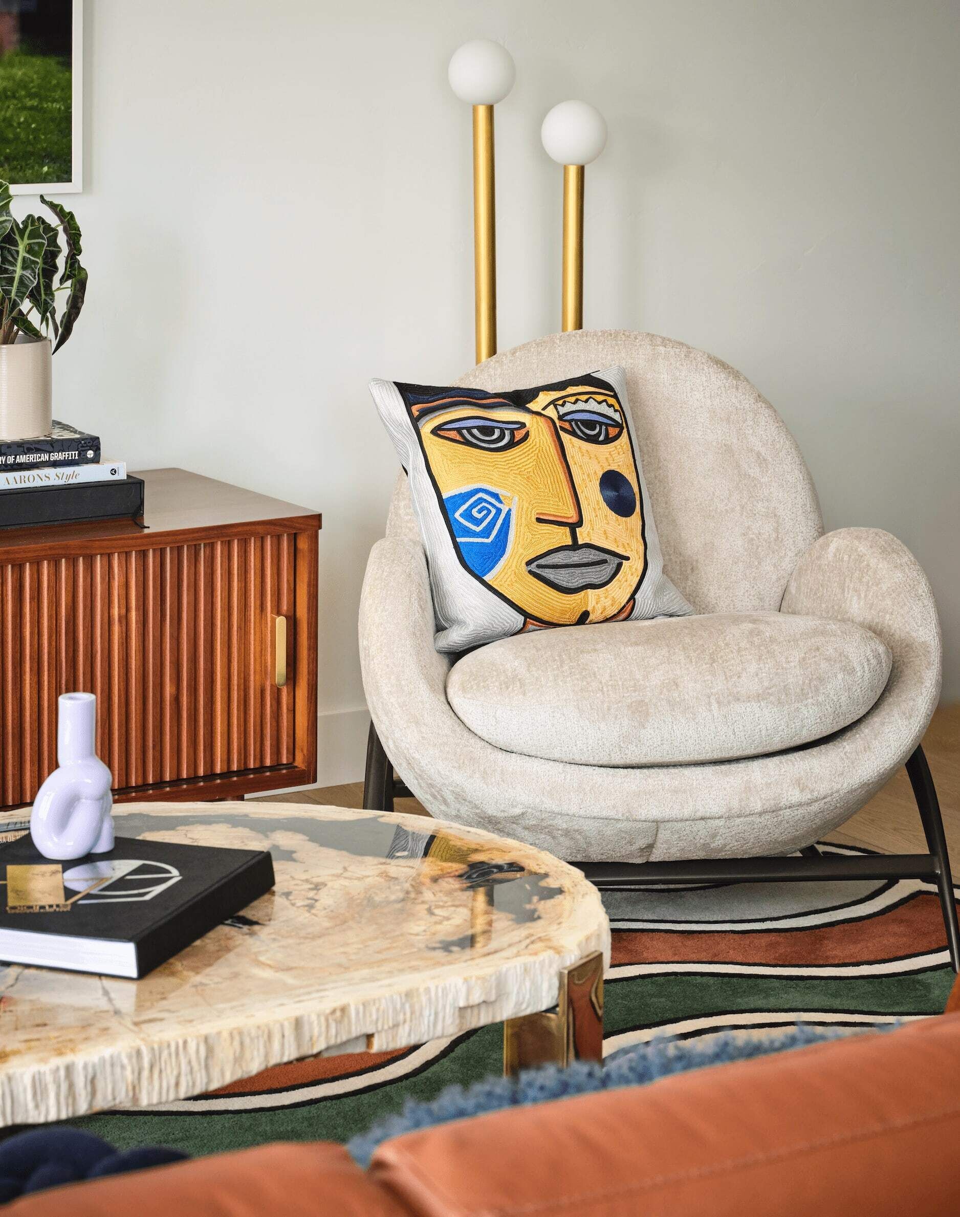A cozy living room with a plush armchair, a wooden sideboard, and a coffee table.