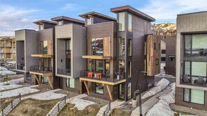 A modern multi-story residential building with balconies and large windows. - Luxury Townhome with Rooftop Spa and Firepit (Steamboat Springs)