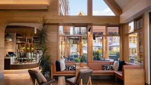 Ein modernes Interieur mit einer Sitzecke, großen Fenstern und Blick ins Freie.