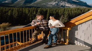 Ein Paar auf einer Holzterrasse mit Blick auf die Berge.