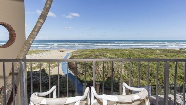 Un balcón con vista a la playa y al océano.