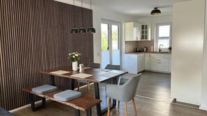 A modern kitchen with white cabinets, a wooden countertop, and a built-in oven. - Exklusive Ferienwohnung bei Berlin, bis 5 Gäste, Große Terrasse, Garten (Bestensee)