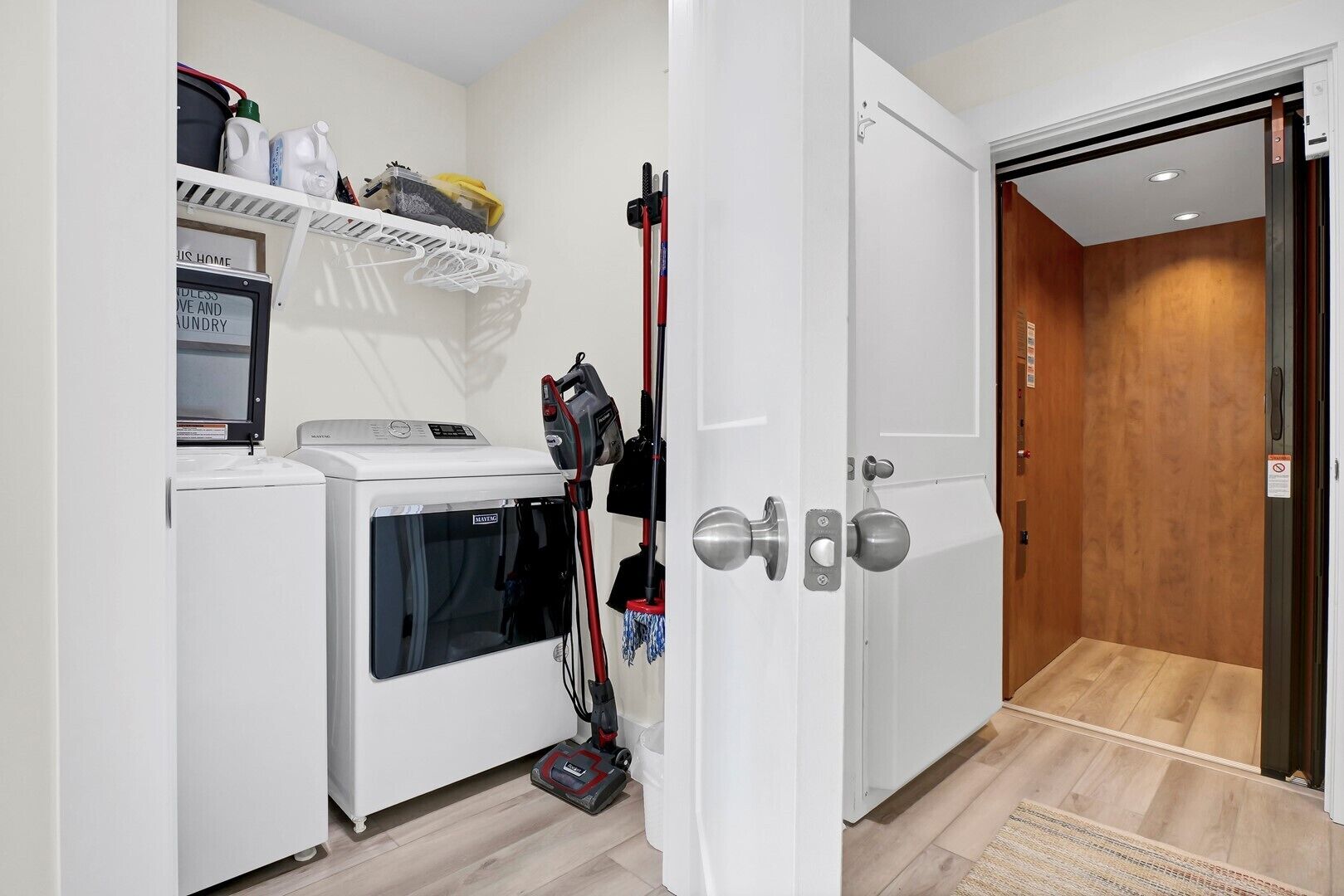 A compact laundry room with a washing machine, dryer, and vacuum cleaner.