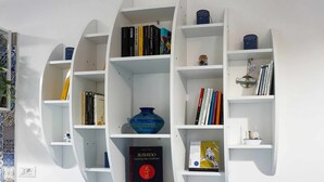 Una libreria bianca con libri e oggetti decorativi.