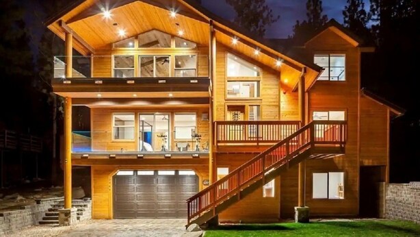 A two-story wooden house with a covered porch, a staircase, and a garage. - 2566 Del Norte 5 Bedroom Home by RedAwning (South Lake Tahoe)