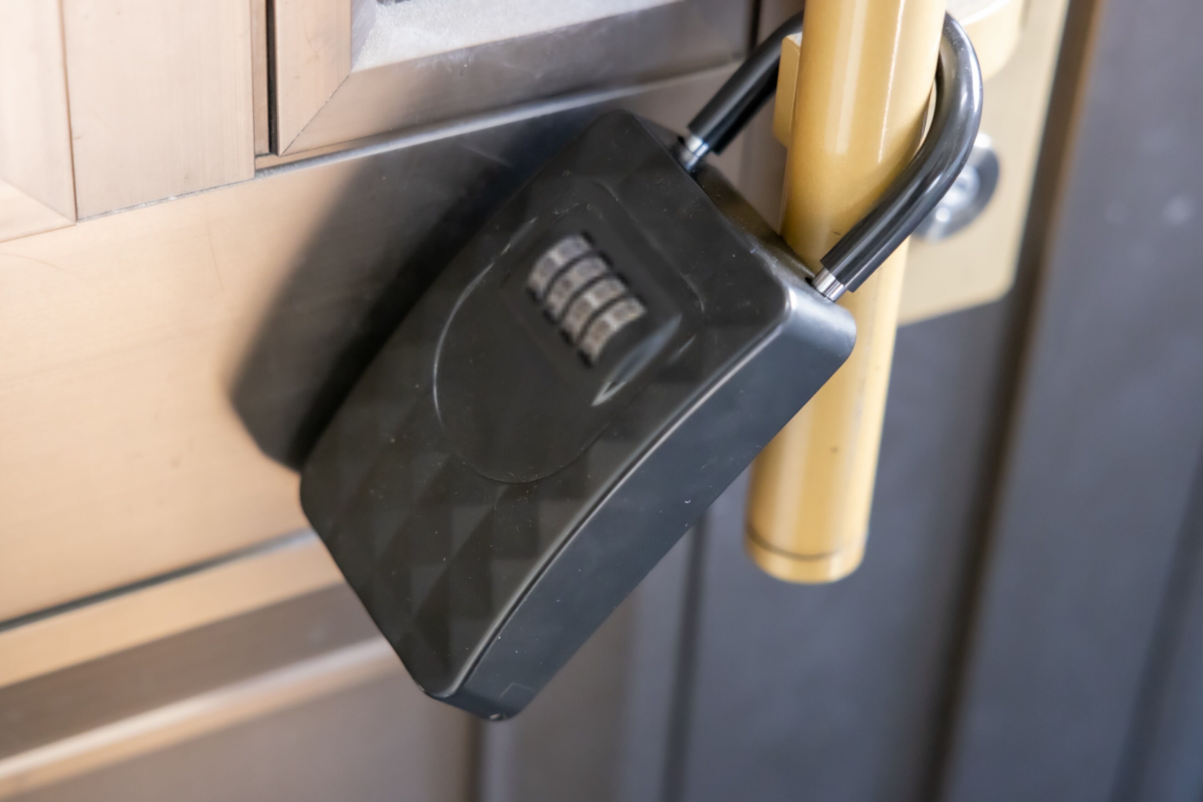 A close-up of a black electronic lock on a beige door handle.
