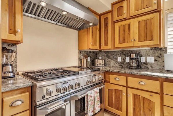 A kitchen with wooden cabinets, a gas stove, an oven, and a coffee maker. - 1603 Bel Aire Circle 3 Bedroom Home by RedAwning (South Lake Tahoe)