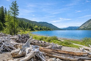 Blick auf einen See mit einer hölzernen Anlegestelle und Treibholz.