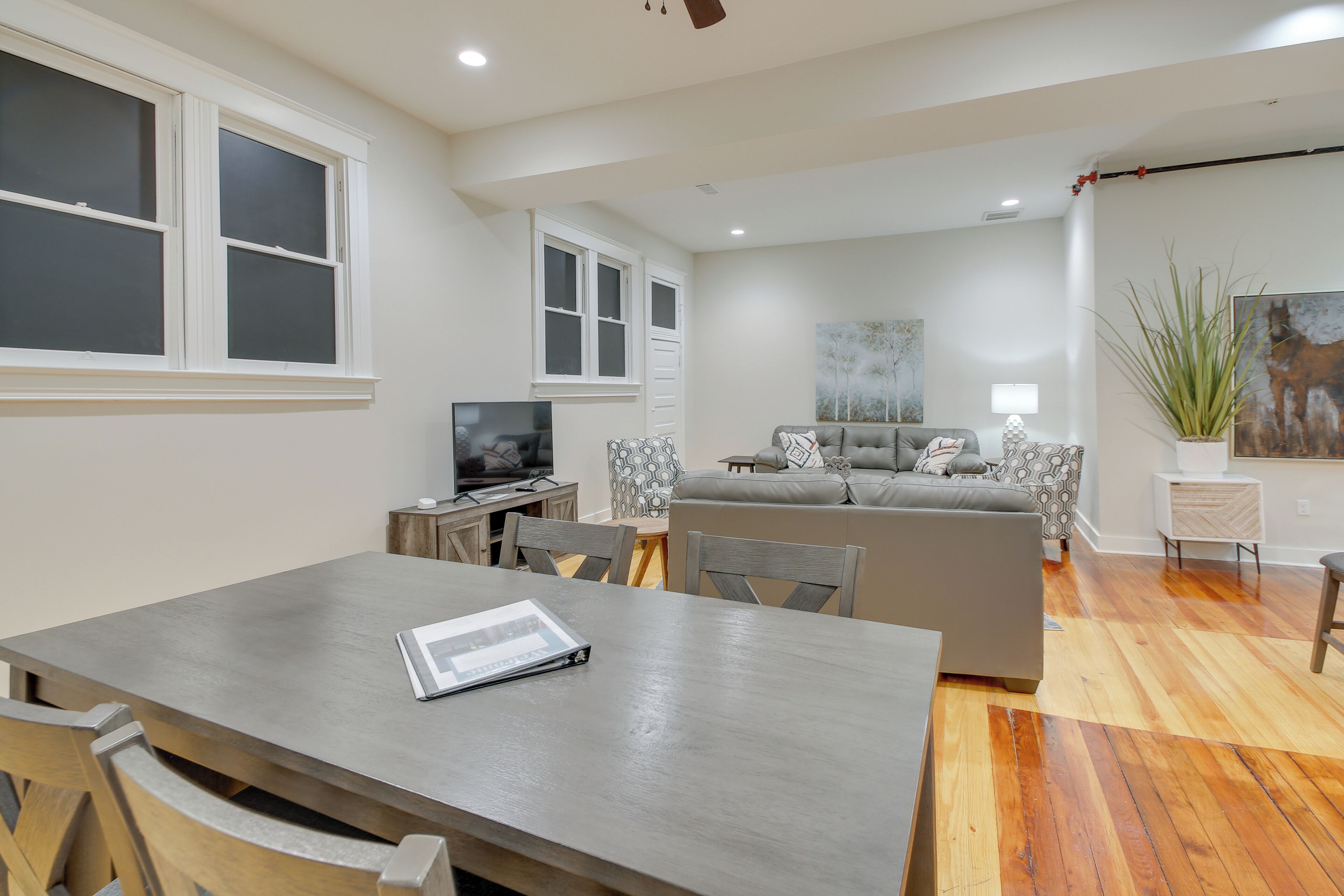 A modern living room with a sofa, a dining table, and a TV.