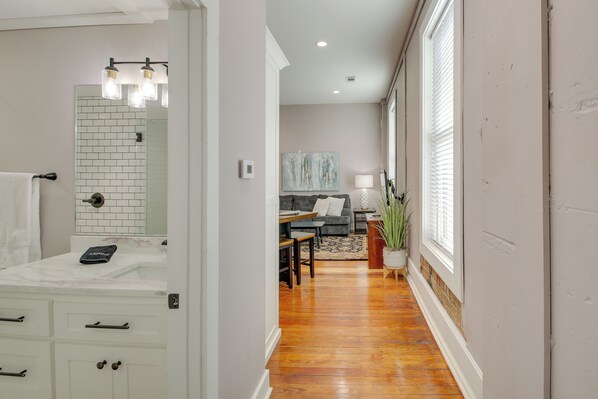 A modern bathroom with a white vanity, a mirror, and a towel rack.