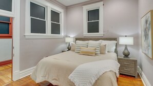 Quarto com uma cama grande, duas mesas de cabeceira e uma janela.