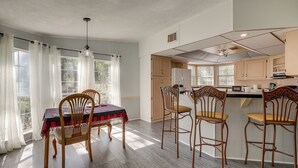 A dining area with a table set for four, wooden chairs, and a window with curtains. - Peaceful Mcalpin Home on 5 Acres w/ Private Deck! (Live Oak)