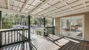 Enjoy dining al fresco on the covered deck with a glass door leading to a cozy dining area.