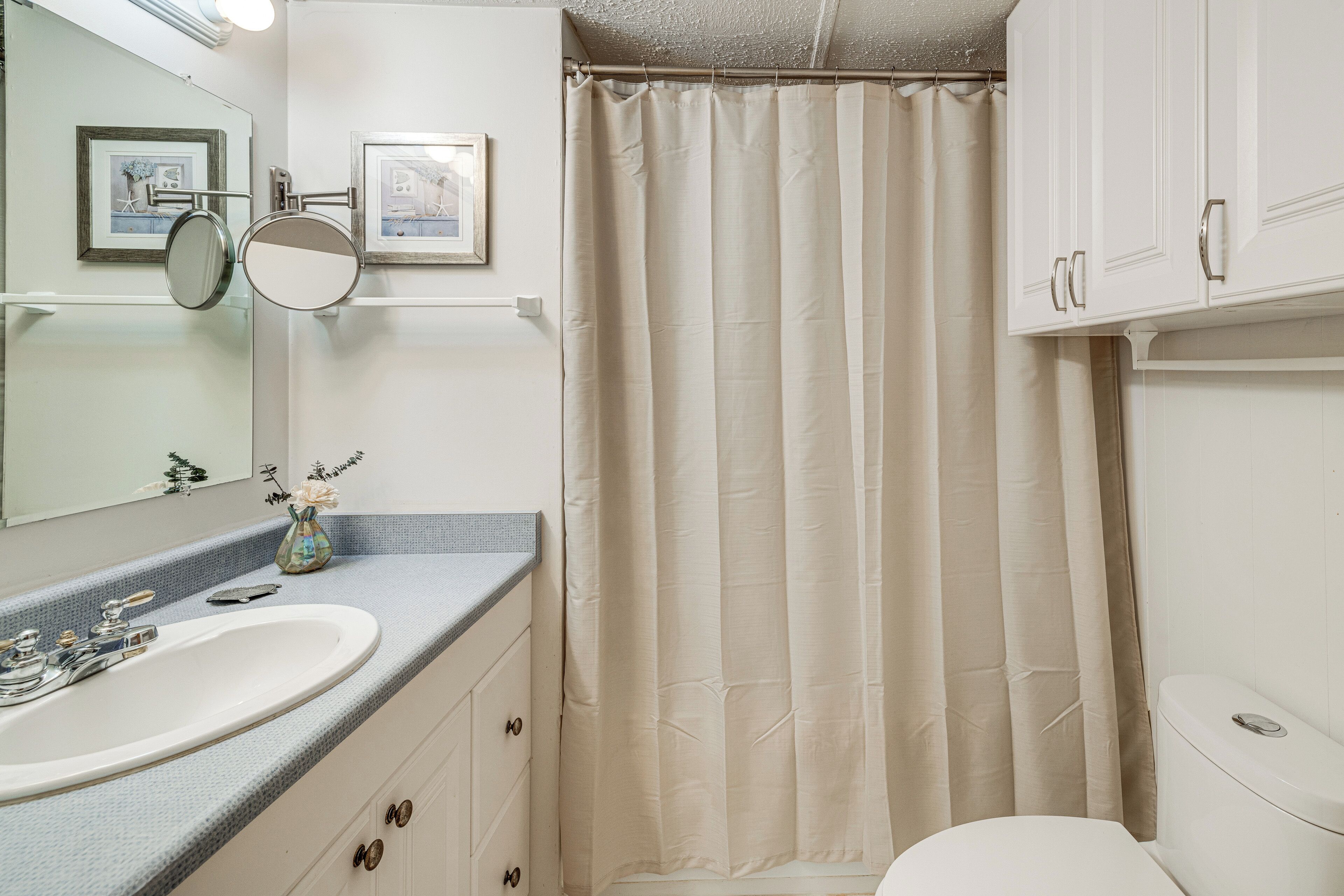 A bathroom with a sink, mirror, and toilet.