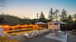 A swimming pool with lounge chairs and a covered seating area, surrounded by trees and a wooden fence. - Wine Country Retreat w/ Pool, 10 Mi to Dtwn Sonoma (Glen Ellen)