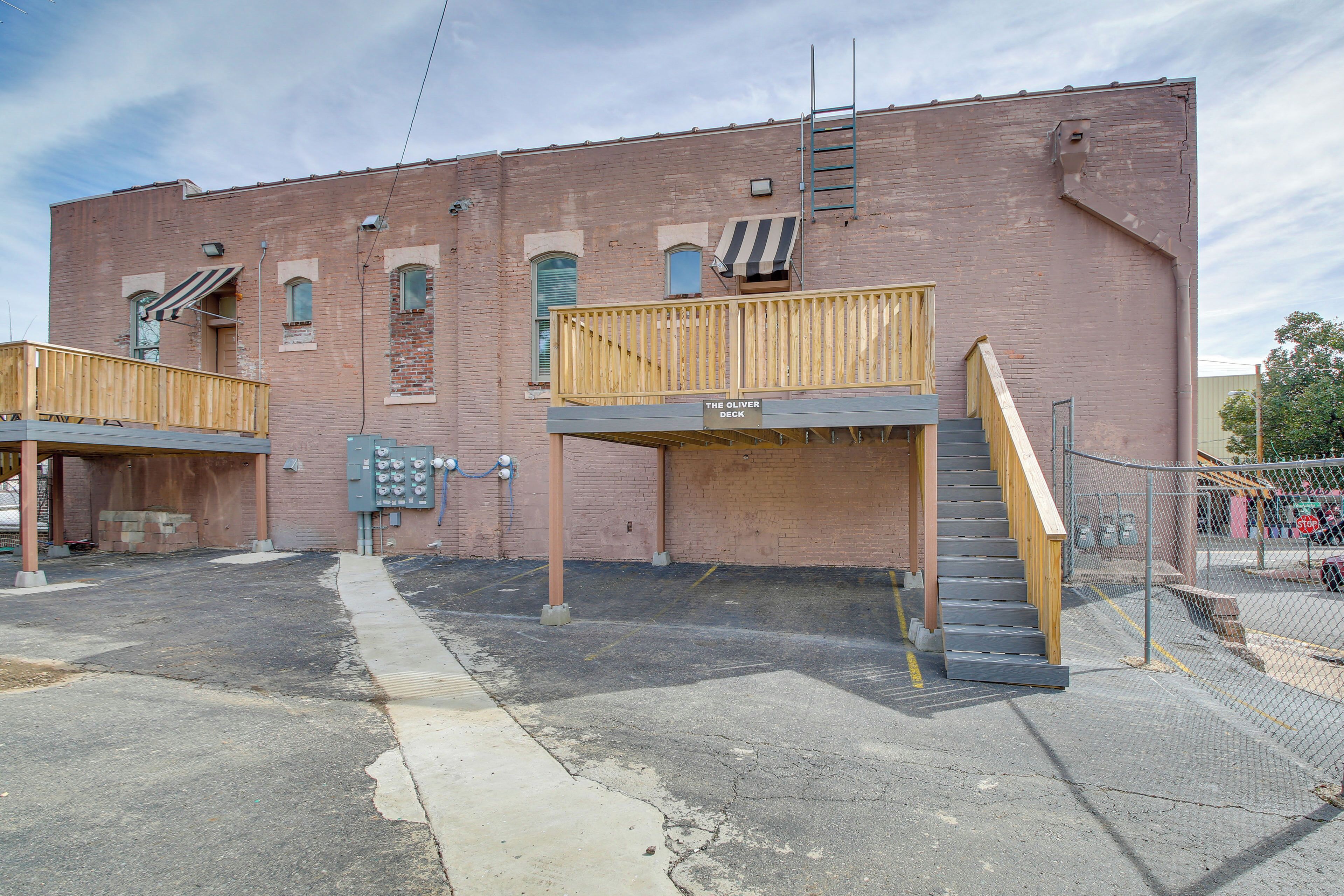 A two-story building with a wooden deck and a staircase leading to an upper level.