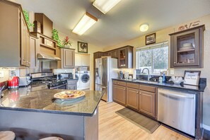 Una cocina moderna con electrodomésticos de acero inoxidable, armarios de madera y una isla central.
