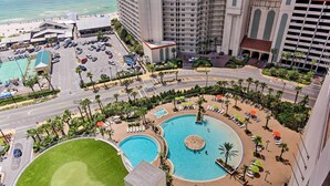Ein Resort mit mehreren Schwimmbecken, einem Golfplatz und einem Parkplatz.