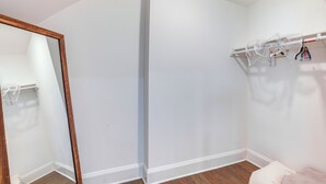 A corner of a room with a white wall, a wooden floor, and a mirror with a wooden frame. - Long Branch Getaway - Walk to Beaches & Dining! (Long Branch)