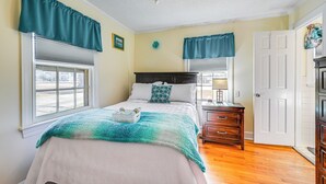 A bedroom with a bed, nightstands, a dresser, and a door. - Greenville Home: 2 Mi to Downtown! 1 Mi to Ecu! (Greenville)