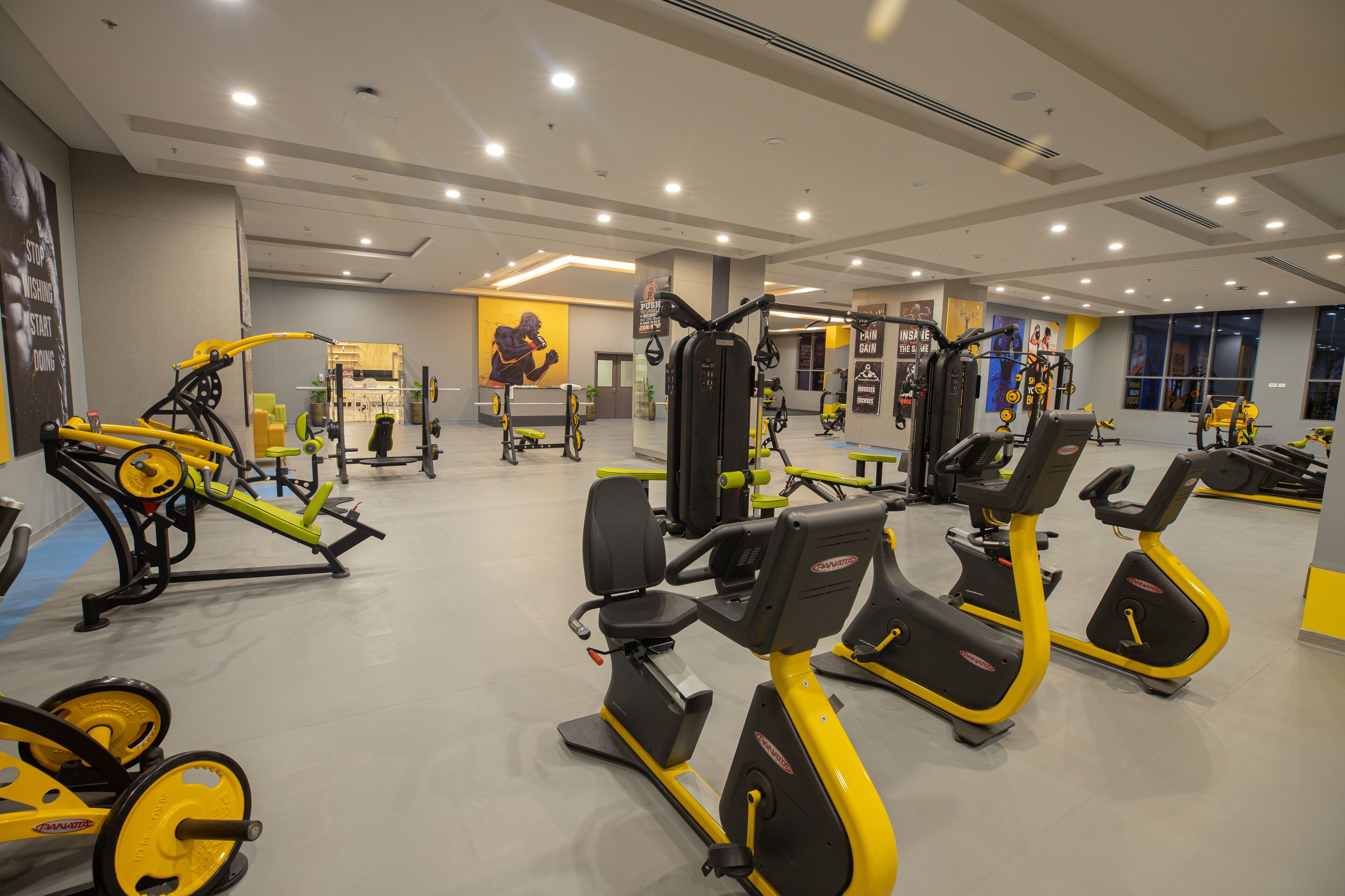 A gym with various exercise equipment, including treadmills, stationary bikes, and weight machines.