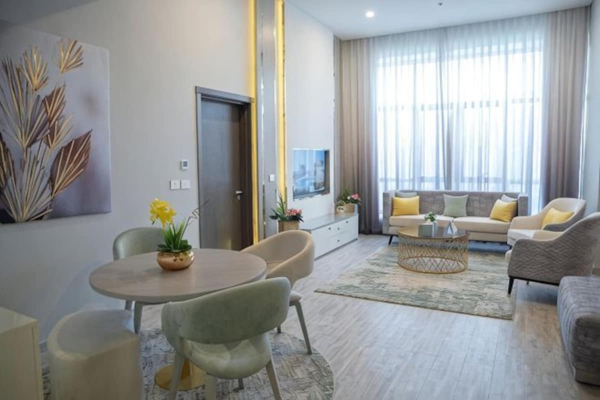 Una sala moderna con un juego de sofá, una mesa de comedor con sillas, un televisor y una puerta.