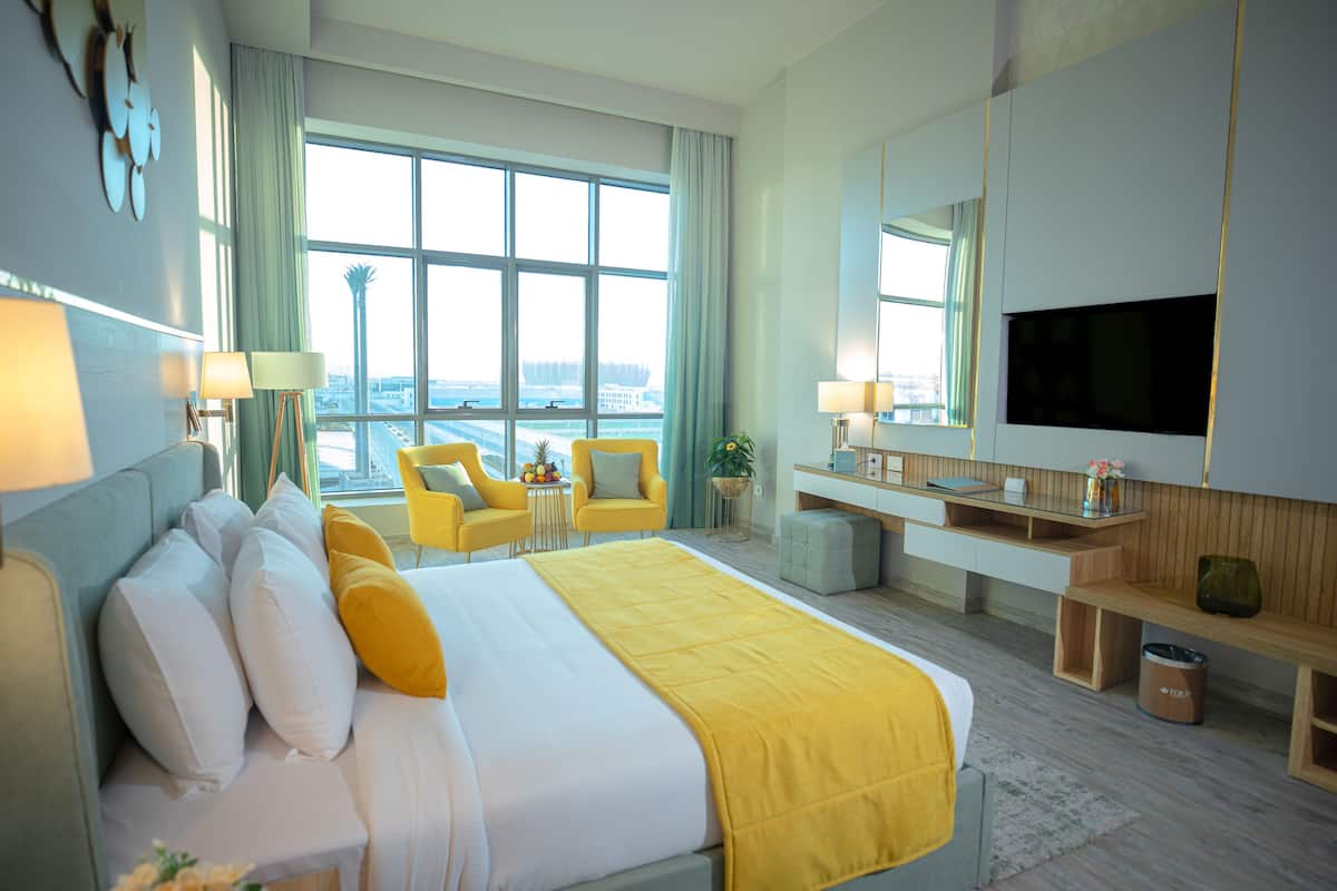 Une chambre d’hôtel avec un grand lit, un bureau, une télévision et une vue sur la ville.