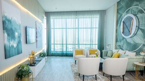 A modern living room with a large window, a sofa set, and a coffee table. - Tolip Hotel Olympic International City (New Cairo)