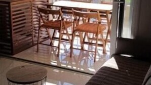 A room with a sliding glass door leading to a balcony with a view of a sports field. - VUE MER Studio Soigné Clim 5 min Plage (Le Lavandou)