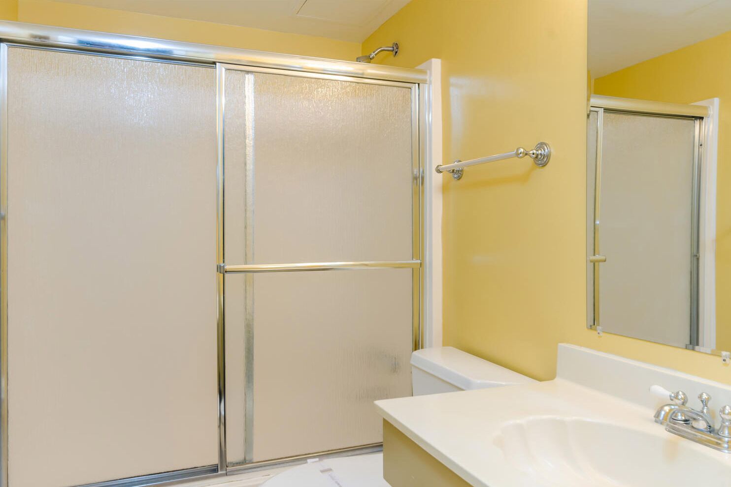Baño con cabina de ducha, lavamanos y espejo.