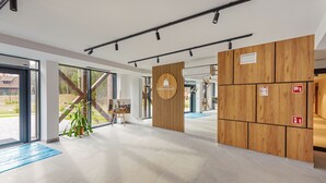 Ein moderner Empfangsbereich mit einer Wand aus Holzpaneelen, einem großen Fenster und einer Rezeption.