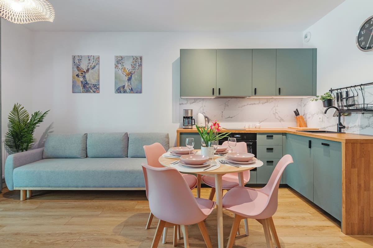 Una cocina moderna con comedor, un sofá y obras de arte en la pared.