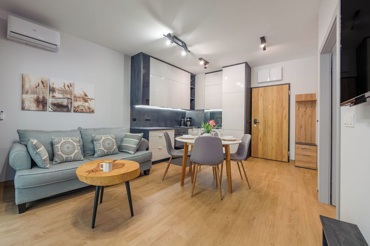 Una sala moderna con sofá, mesa de centro y comedor.