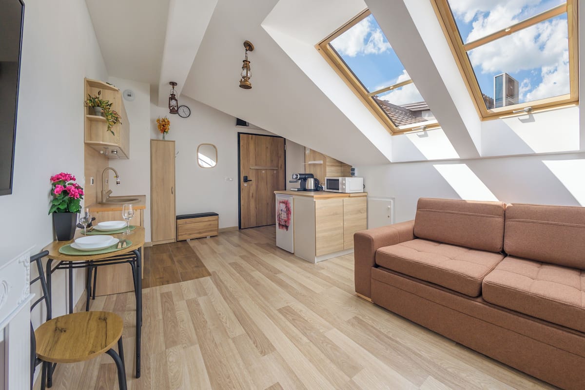 Un apartamento tipo loft con comedor, kitchenette y sofá.