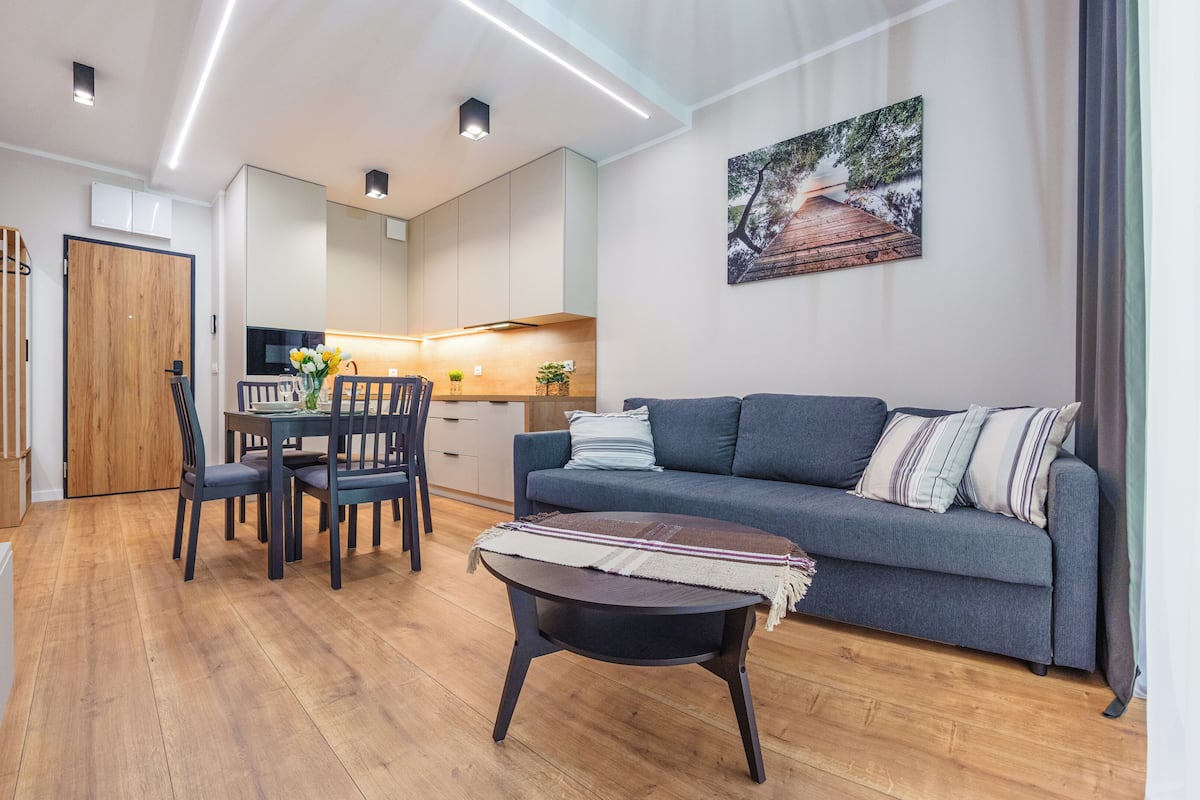 Una sala de estar moderna con un sofá, una mesa de centro y un comedor con sillas y una mesa.