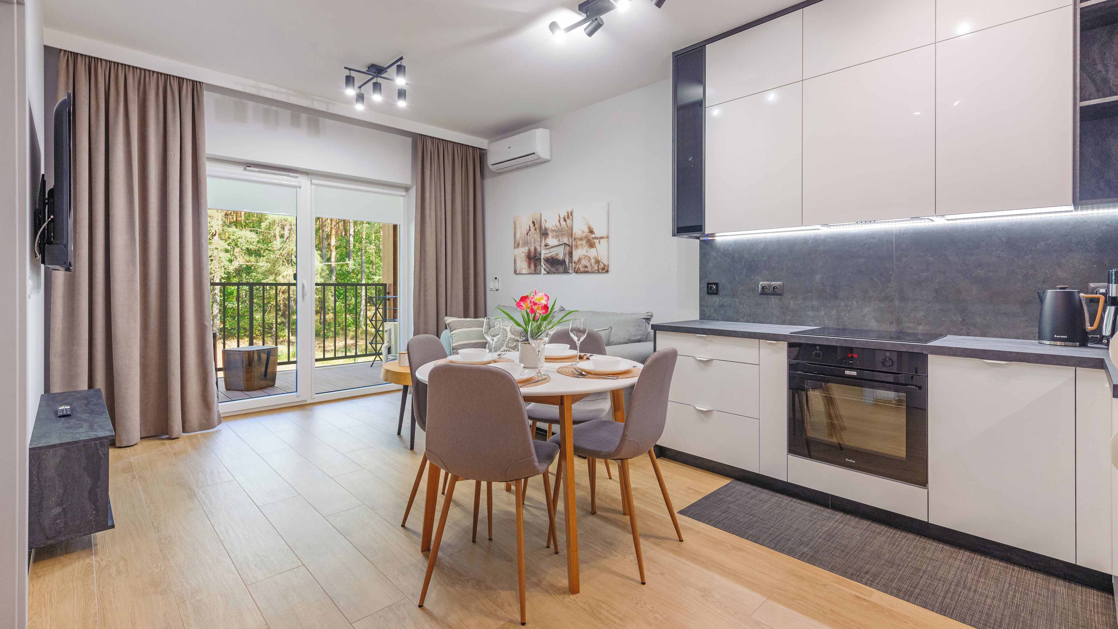 Una cucina moderna con zona pranzo, dotata di forno a incasso, macchina del caffè e vista sull'esterno.