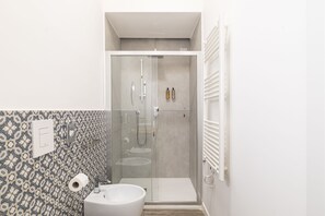 Habitación superior, vistas a la ciudad | Baño | Ducha, cabezal de ducha tipo lluvia, secador de pelo y zapatillas
