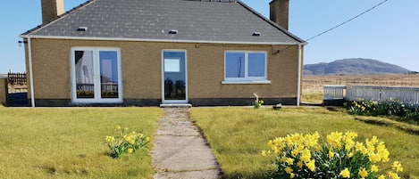 A two-story house with a tiled roof, a front door, and a visible chimney.