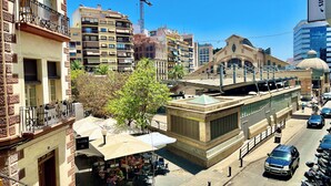 A street view with a café area, a building with a dome, and parked cars. - TresColores  (Alicante)