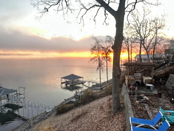 A lakeside view with a gazebo, dock, and benches.