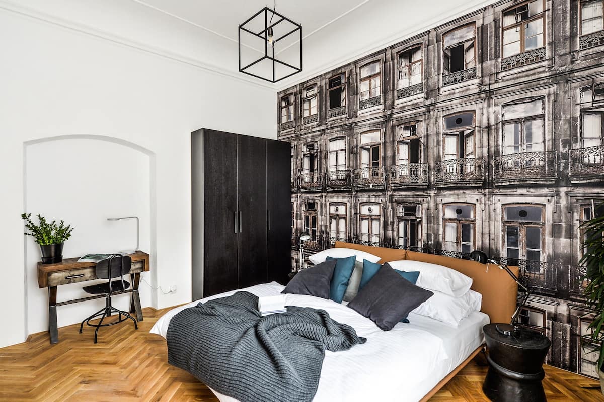 A bedroom with a large bed, a desk, and a wardrobe.