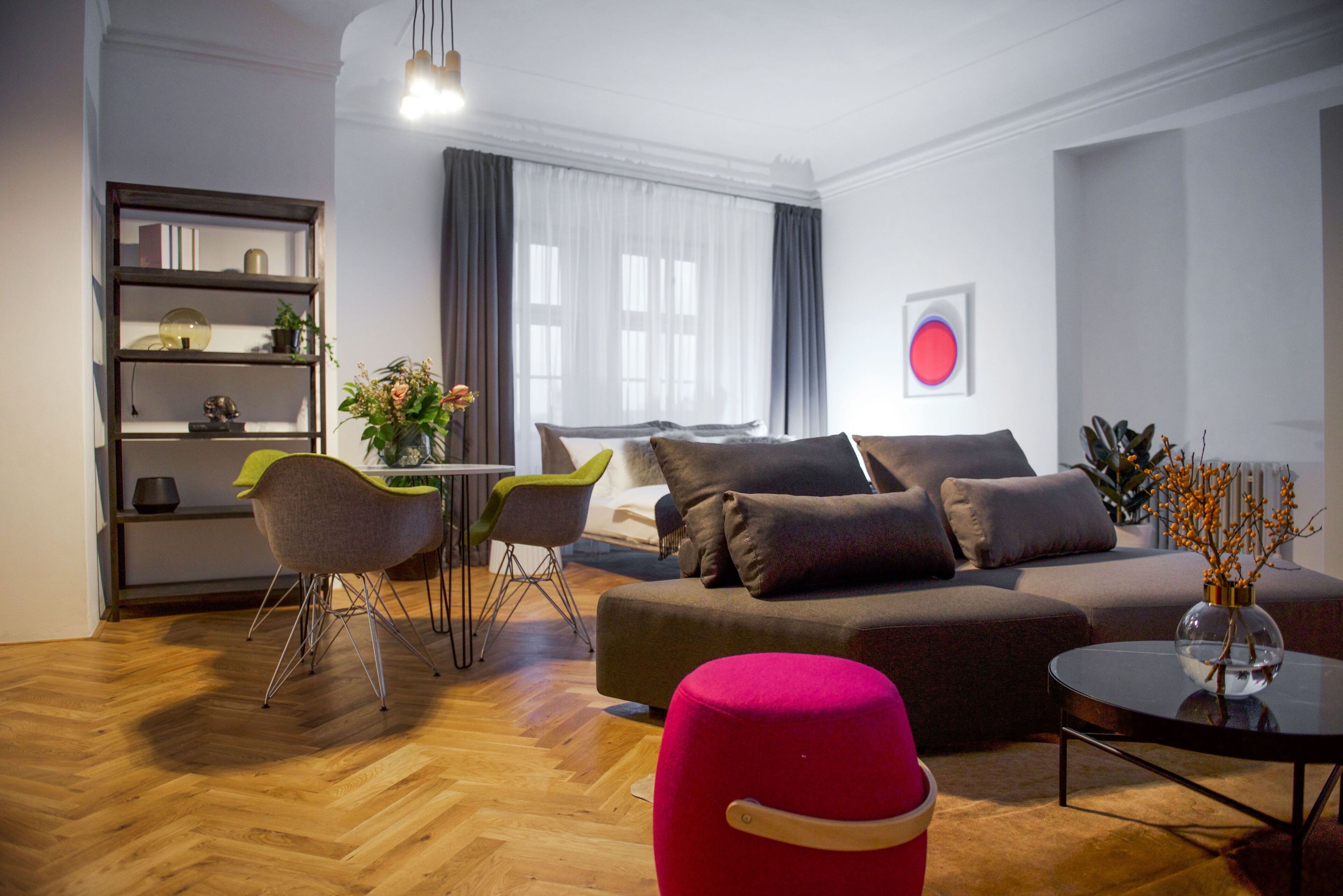 A modern living room with a sofa, chairs, a coffee table, and a bookshelf.
